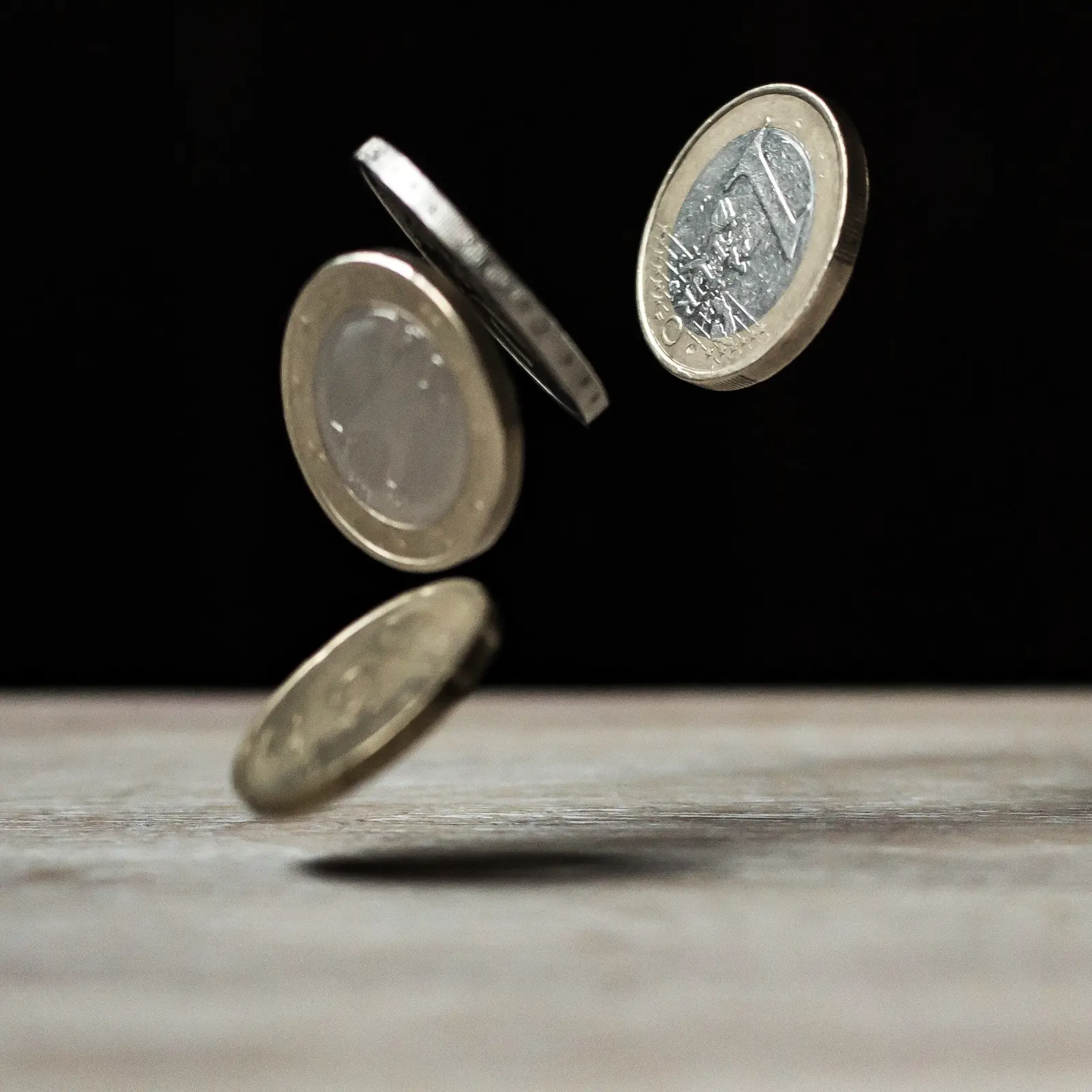 Pièces en euros tombant sur une table en bois